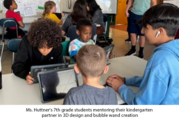 Students sitting at a table working on digital tablets with each other