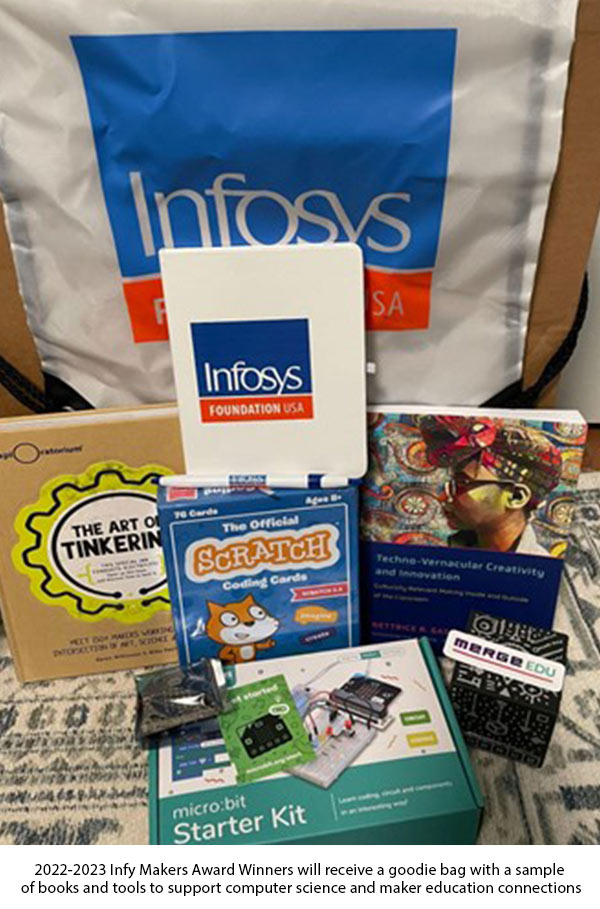 Infosys Foundation USA gift bag contents displayed with the books The Art of Tinkering and Techno-Vernacular Creativity, a set of boxed Scratch coding cards, a micro:bit circuit set with a boxed starter kit, a Merge Cube from Merge Edu and Infosys Foundation USA journals and pens