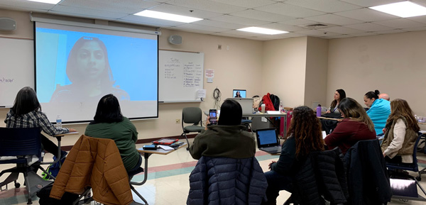 Image shows a room of educators attending a webinar